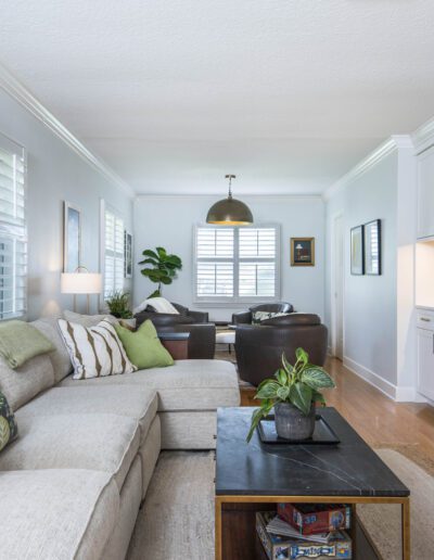 Bright and spacious living room with modern decor, a large sectional sofa, and built-in cabinetry.