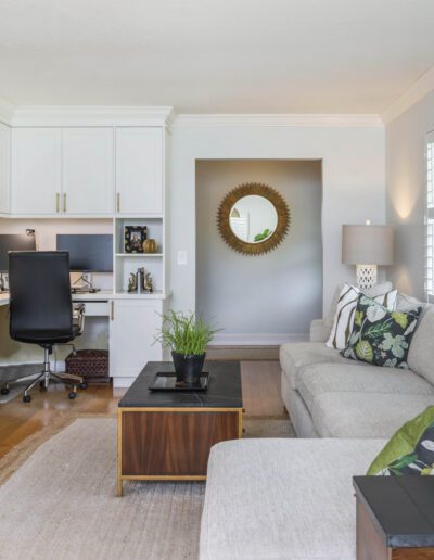 Modern living room with an integrated home office space, featuring a neutral color palette and natural light.