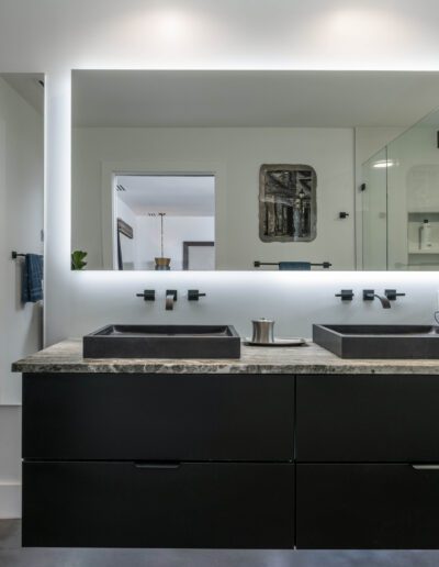 Modern bathroom with double vanity and backlit mirror.