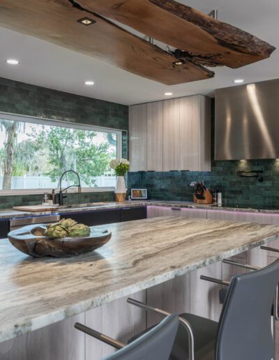 Modern kitchen interior with wooden countertops, stainless steel appliances, and green tile backsplash.