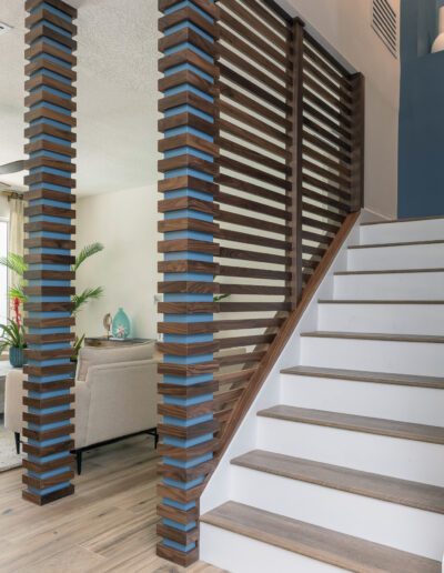 Modern staircase with wooden slats railing in a contemporary home interior.