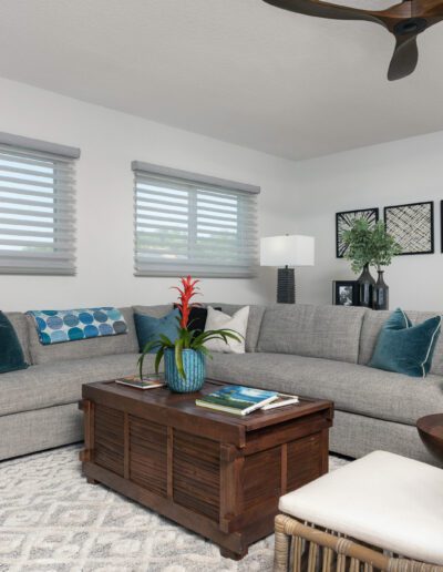 A neatly-arranged living room with a gray sectional sofa, wooden coffee table, and decorative items.