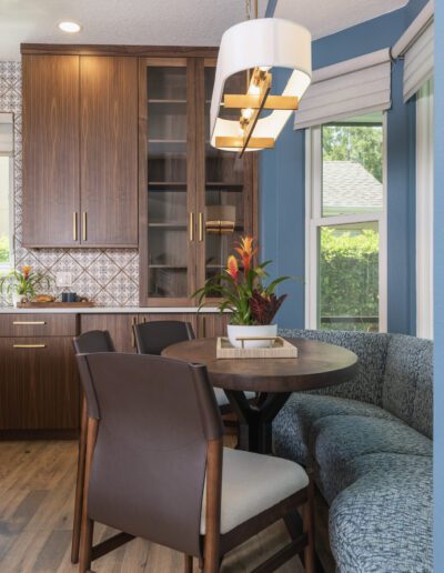 Modern dining area with wooden cabinetry, patterned backsplash, and a stylish pendant light.