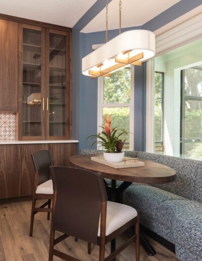 Modern kitchen nook with a round dining table, upholstered bench seating, and a pendant light fixture.