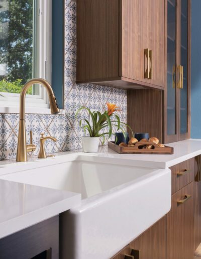 Modern kitchen interior with patterned backsplash, wooden cabinets, and a white farmhouse sink.