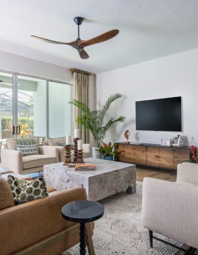 A modern, well-lit living room with contemporary furnishings and a view of an enclosed patio.