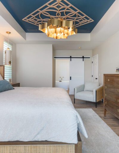 Contemporary bedroom featuring a neatly-made bed, a geometric ceiling light, and a sliding barn door.