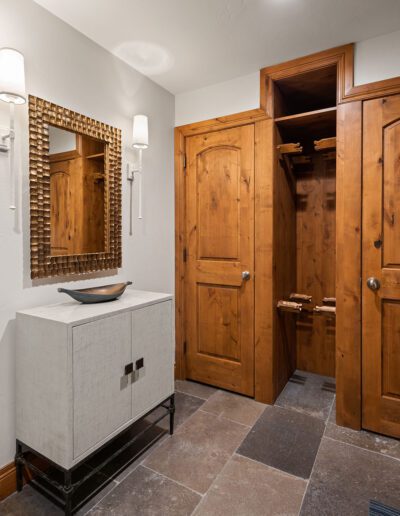 Modern bathroom interior with a vessel sink vanity and wooden doors leading to an adjacent room.