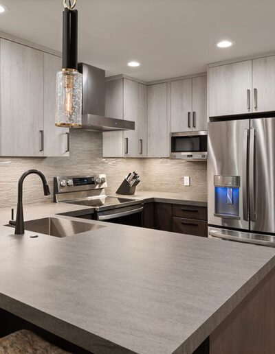 Modern kitchen with stainless steel appliances and gray cabinetry.