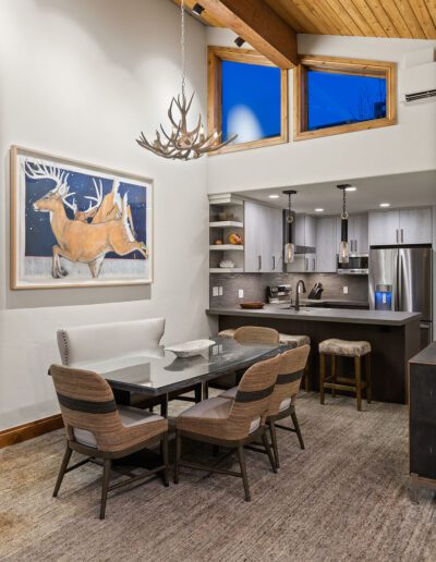 Modern dining area with an open concept kitchen, high ceilings, and rustic decor elements.