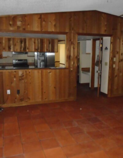 Interior of a room with wooden wall paneling, a tile floor, and a printer on a counter.